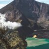 Breathtaking landscape of Rinjani active volcano and crater lake surrounded by rough formations on sunny day