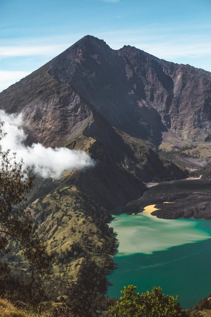 Breathtaking landscape of Rinjani active volcano and crater lake surrounded by rough formations on sunny day